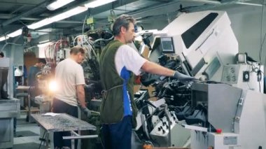 Ayakkabı üretim fabrikası. Fabrika işçileri son çizmeler için endüstriyel makine kullanıyorlar.