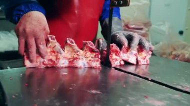 Et işleme fabrikası, gıda üretim tesisi. Fabrika çalışanı kemikleri etle kesmek için bir mekanizma kullanıyor.