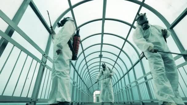Dezinfektory rozstřikují chemikálie v chodcovém tunelu — Stock video