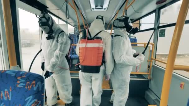 Desinfección, protección antivirus, concepto de prevención covid-19. Grupo de inspectores están desinfectando el autobús desde dentro — Vídeos de Stock