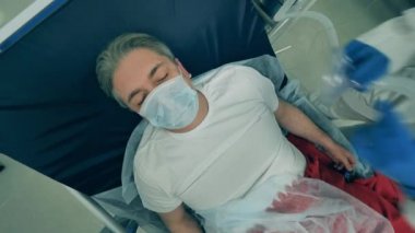 Sağlık çalışanı bir adamı solunum sistemine bağlıyor. Coronavirus, kovid 19 hastası bir hastanede yoğun bakımda..