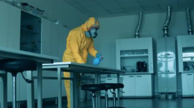 Laboratuvardaki masa bir hijyen işçisi tarafından temizleniyor.
