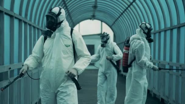 Bir grup dezenfektan bir tünelde kimyasal tedavi uyguluyor. Dezenfeksiyon, koruyucu temizlik, covid-19 önleme kavramı. — Stok video