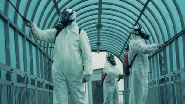 Covid-19, koronavírus világjárvány, fertőtlenítési koncepció. Az utcai alagutat kémiailag fertőtlenítik az ellenőrök. — Stock videók