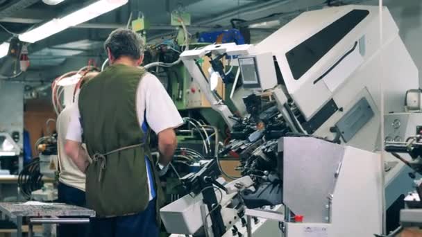 Trabalhadores industriais estão gerenciando máquinas de fábrica para fazer sapatos. Trabalhadores da fábrica de calçado fazendo sapatos. — Vídeo de Stock