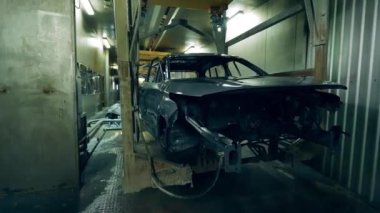 Bir arabanın tamamlanmamış bedeni mekanik olarak taşınıyor.