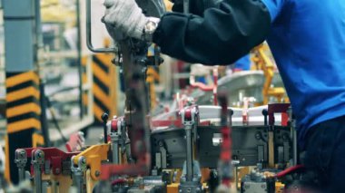 Araba parçası bir fabrika işçisi tarafından kaynak ediliyor. Otomotiv endüstrisi kavramı.