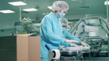 Eczacı, ilaç endüstrisi konsepti. İlaçları sınıflandıran ve paketleyen birkaç sağlık çalışanı.