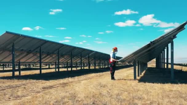 Erkek mühendis açık havada güneş enerjisi alanında çalışıyor. — Stok video