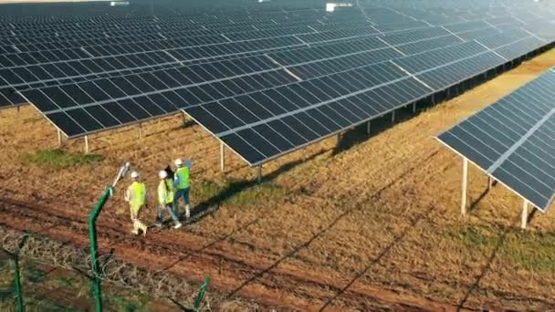 Bir grup mühendisle birlikte bir fotovoltaik enerji santralinin üst görüntüsü — Stok video
