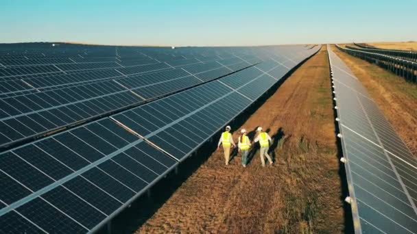 Vista superior de especialistas caminhando através de uma usina de energia solar. Energia renovável, conceito de eletricidade solar. — Vídeo de Stock