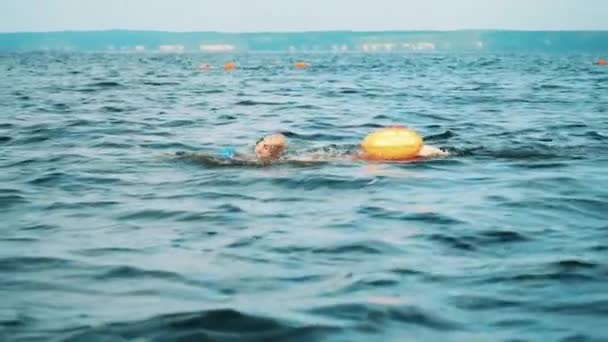 Athlète masculin nageant dans une rivière avec un flotteur de remorquage — Video