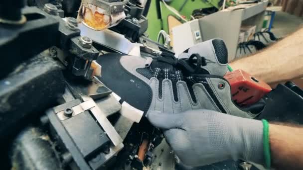 Gyári munkás használ egy gépet, hogy alakítsa a cipő — Stock videók