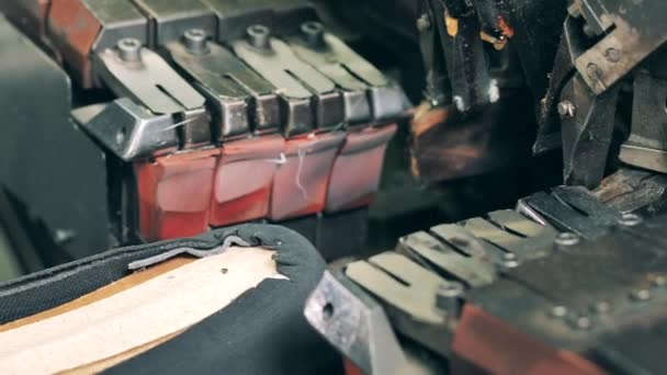 Een schoenmaker maakt een schoen met een machine in een schoenenfabriek. Sluiten. — Stockvideo