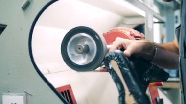 Ayakkabı üreticisi ayakkabı fabrikasında ayakkabı öğütüyor.