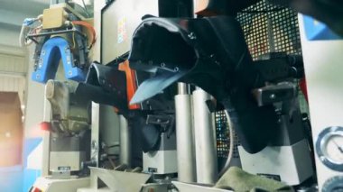 Ayakkabı fabrikası işçisi ayakkabıları şekle sokuyor.