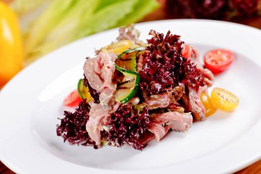 Eti, ızgara kabak, beyaz tabakta domates salatası. Yakın çekim