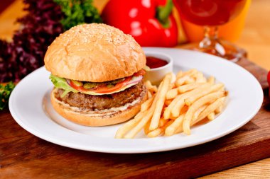 Lezzetli sığır eti hamburger ve patates kızartması beyaz tabakta. Yakın çekim