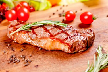 Ahşap kesme tahtası üzerinde ızgara sığır eti biftek. Yakın çekim