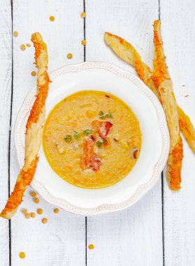 Bezelye çorbası pastırma ile ahşap arka plan üzerinde grisini ile devam eder. Üstten görünüm. Yakın çekim