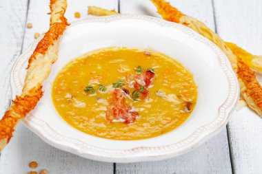 Bezelye çorbası pastırma ile ahşap arka plan üzerinde grisini ile devam eder. Yakın çekim