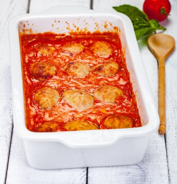 Ahşap arka plan üzerinde beyaz güveç çanağı domates ve ekşi krema soslu köfte. Yakın çekim