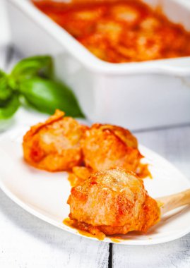 Beyaz tabakta domates ve ekşi krema soslu köfte. Yakın çekim