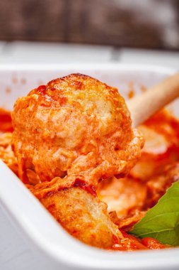 Beyaz güveç çanağı içinde domates ve ekşi krema soslu köfte. Yakın çekim