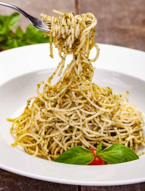 İtalyan makarna beyaz plaka üzerinde ev yapımı pesto soslu spagetti. Yakın çekim
