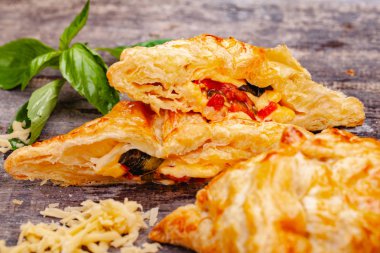 Puf böreği kiraz domates, mozzarella peyniri ve fesleğen ahşap rustik masa üzerinde. Yakın çekim