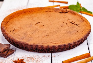 Ahşap rustik masa üzerinde tarçın ile çikolatalı pasta. Yakın çekim