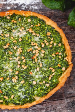 Ispanak, ricotta peyniri ve çam fıstığı ahşap rustik masa üzerinde tart. Yakın çekim