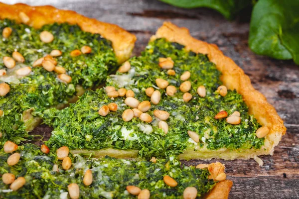 Ispanak, ricotta peyniri ve çam fıstığı ahşap rustik masa üzerinde tart. Yakın çekim