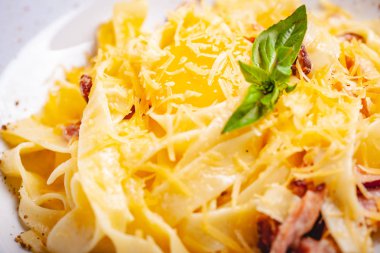 İtalyan mutfağı. Pastırmalı makarna, peynir ve yumurta. Kapat.