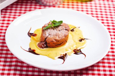 Çikolatalı fondan ile muhallebi krem beyaz tabakta servis. Lav kek tarifi. Yakın çekim