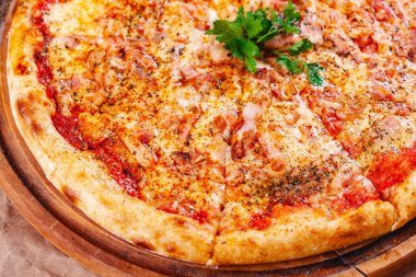 Pastırmalı İtalyan pizzası, domates ve ahşap kesim tahtasında mozzarella peyniri. Kapat.