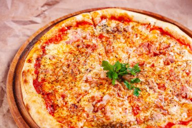 Pastırmalı İtalyan pizzası, domates ve ahşap kesim tahtasında mozzarella peyniri. Kapat.