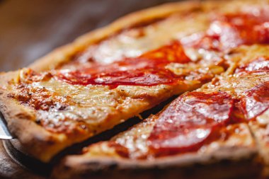 İtalyan Pepperoni pizzası mozzarella peyniri ve ahşap tahtada salam. Kapat.