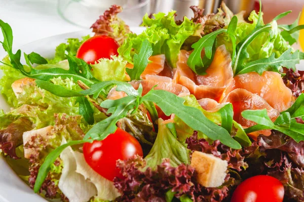 Somon, cherry domates, kruton ve beyaz tabakta marul salatası. Yakın çekim