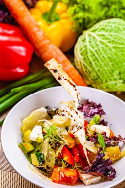 Beyaz plaka üzerinde farklı sebze ile soğanlı salata