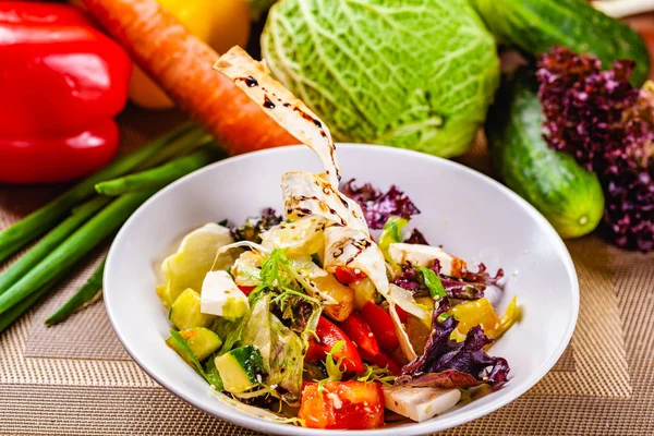 Beyaz plaka üzerinde farklı sebze ile soğanlı salata