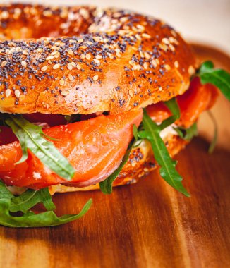 Simit krem peynir, somon füme ve roka salatası ahşap tahta üzerinde. Yakın çekim