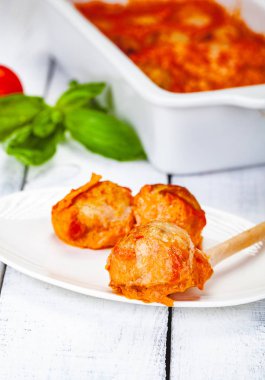 Beyaz tabakta domates ve ekşi krema soslu köfte. Yakın çekim