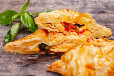 Puf böreği kiraz domates, mozzarella peyniri ve fesleğen ahşap rustik masa üzerinde. Yakın çekim