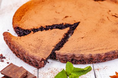 Tarçın ile çikolatalı pasta ahşap rustik masanın üzerine dilimlenmiş. Yakın çekim