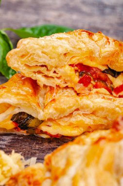 Puf böreği kiraz domates, mozzarella peyniri ve fesleğen ahşap rustik masa üzerinde. Yakın çekim