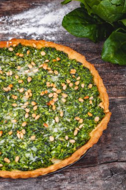 Ispanak, ricotta peyniri ve çam fıstığı ahşap rustik masa üzerinde tart. Yakın çekim