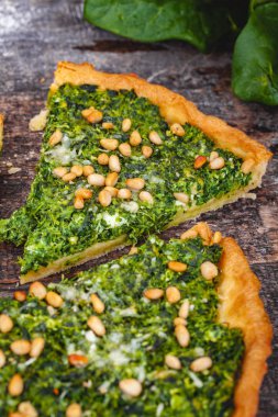 Ispanak, ricotta peyniri ve çam fıstığı ahşap rustik masa üzerinde tart. Yakın çekim