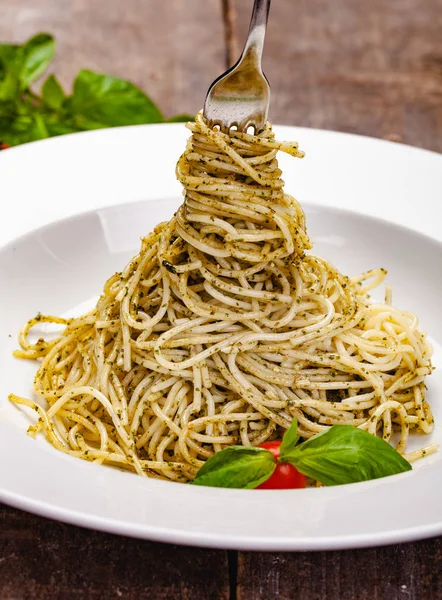 İtalyan makarna beyaz plaka üzerinde ev yapımı pesto soslu spagetti. Yakın çekim