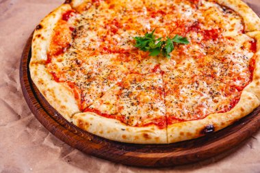 Domatesli İtalyan Pizza Margherita ve ahşap kesim tahtasında mozzarella peyniri. Kapat.